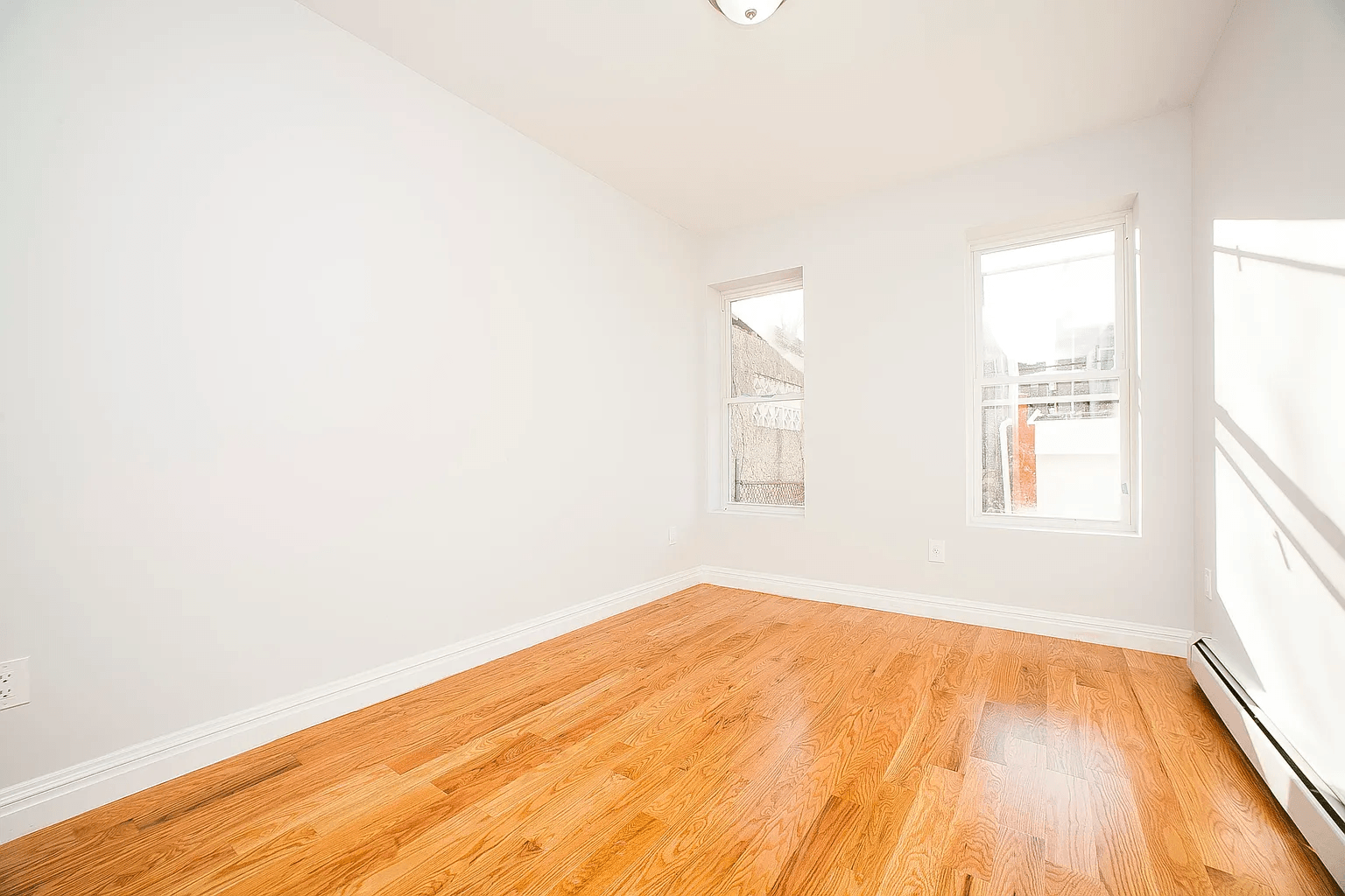 581 Van Siclen Avenue Brooklyn, NY 11207 - Photo 8 of 16 a view of empty room with wooden floor and fan