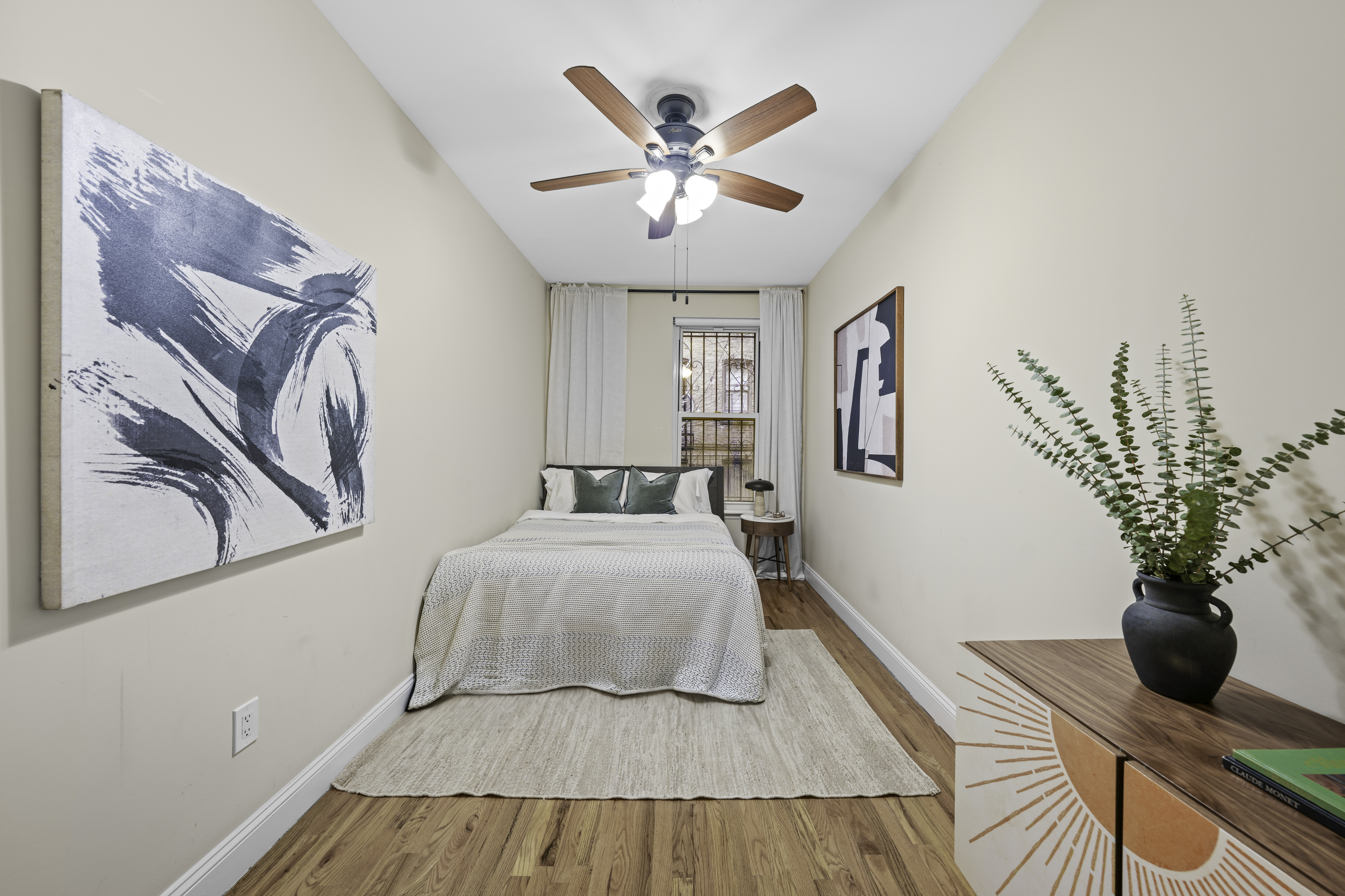 714 St Nicholas Avenue, Unit 1 Manhattan, NY 10031 - Photo 7 of 18 a bedroom with a large bed and a chandelier