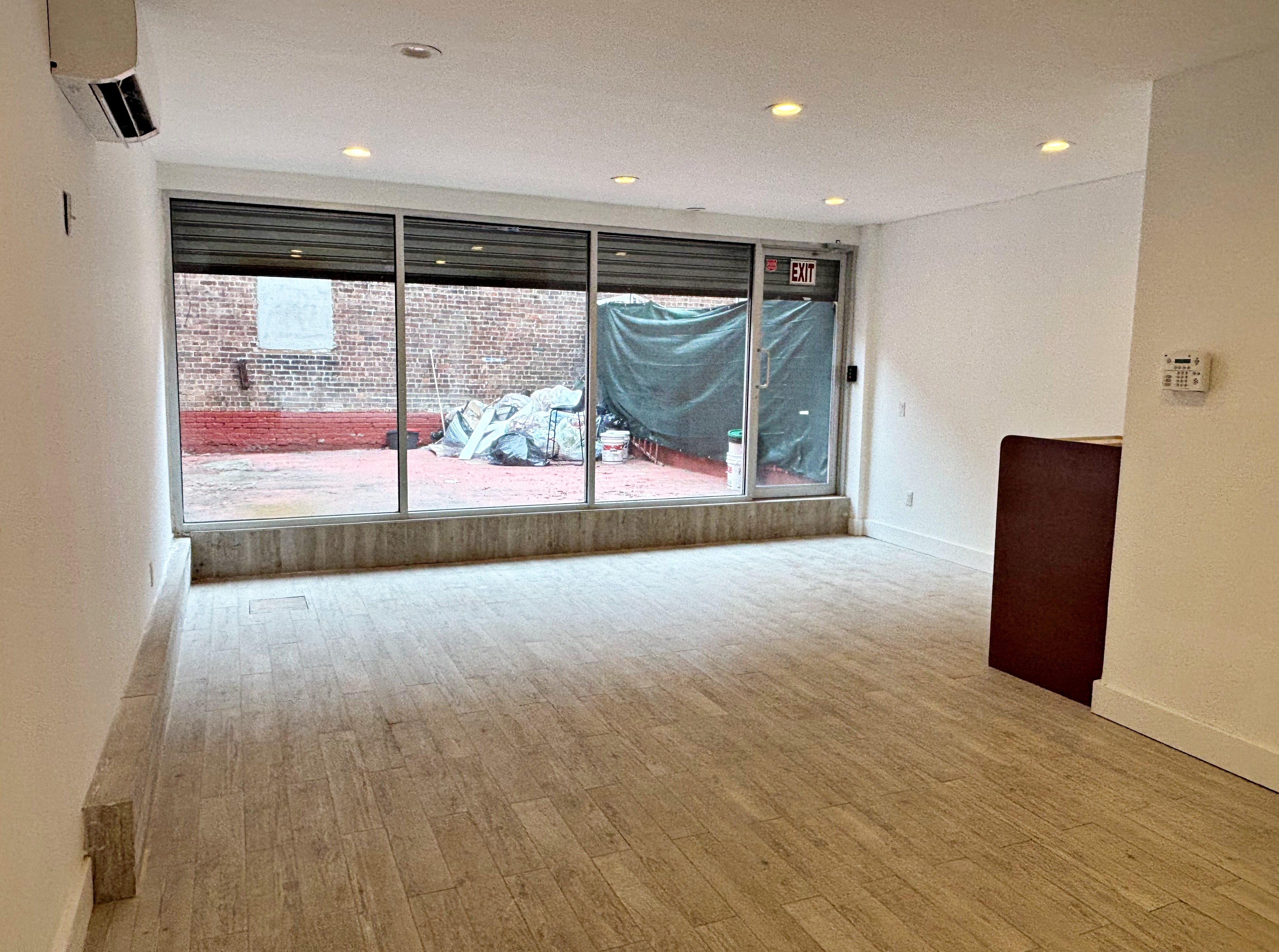 385 Nostrand Avenue, Unit Undisclosed Brooklyn, NY 11216 - Photo 6 of 27 a view of an empty room with wooden floor and a window