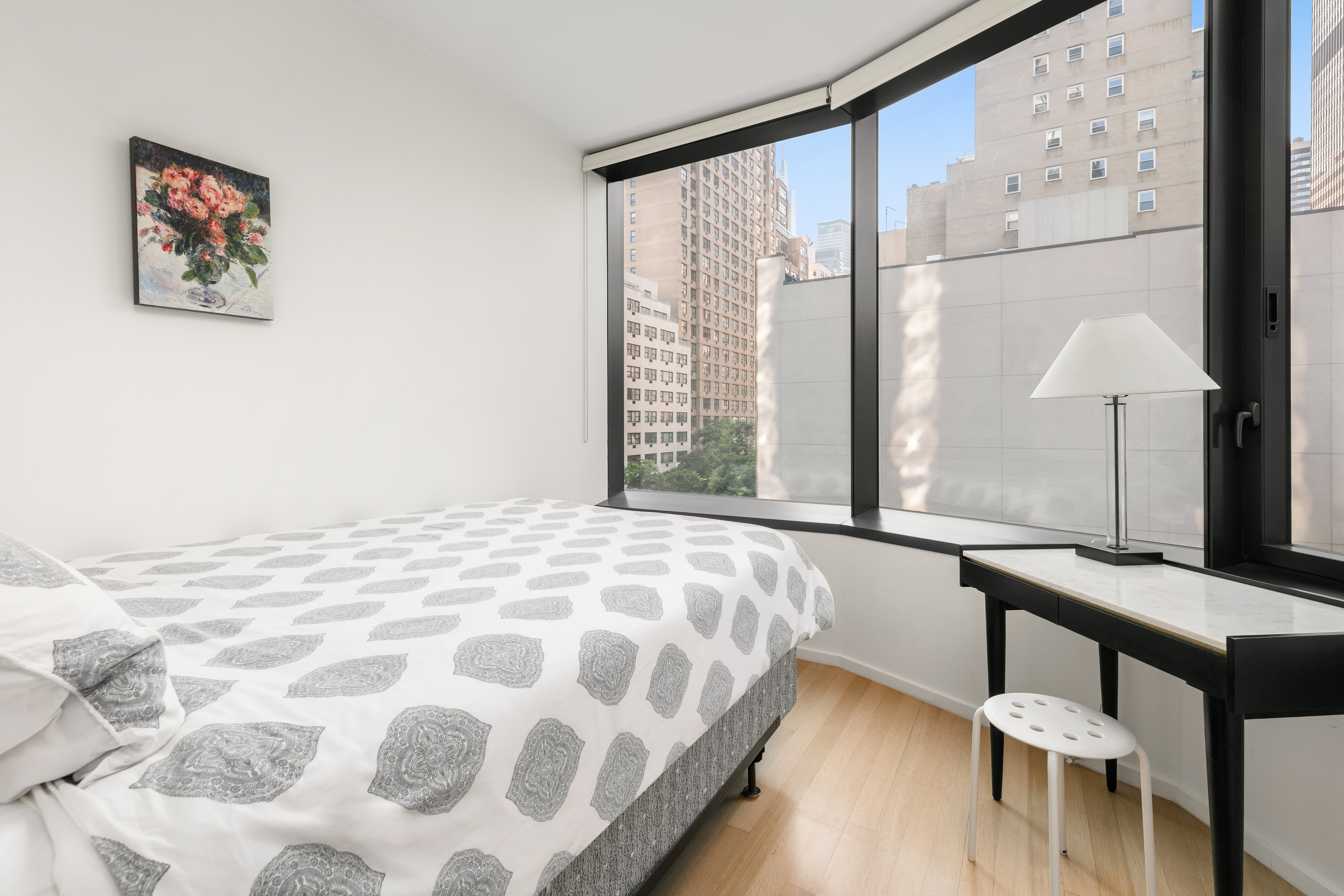 50 United Nations Plaza, Unit 6C Manhattan, NY 10017 - Photo 11 of 15 a bedroom with a bed window and a table
