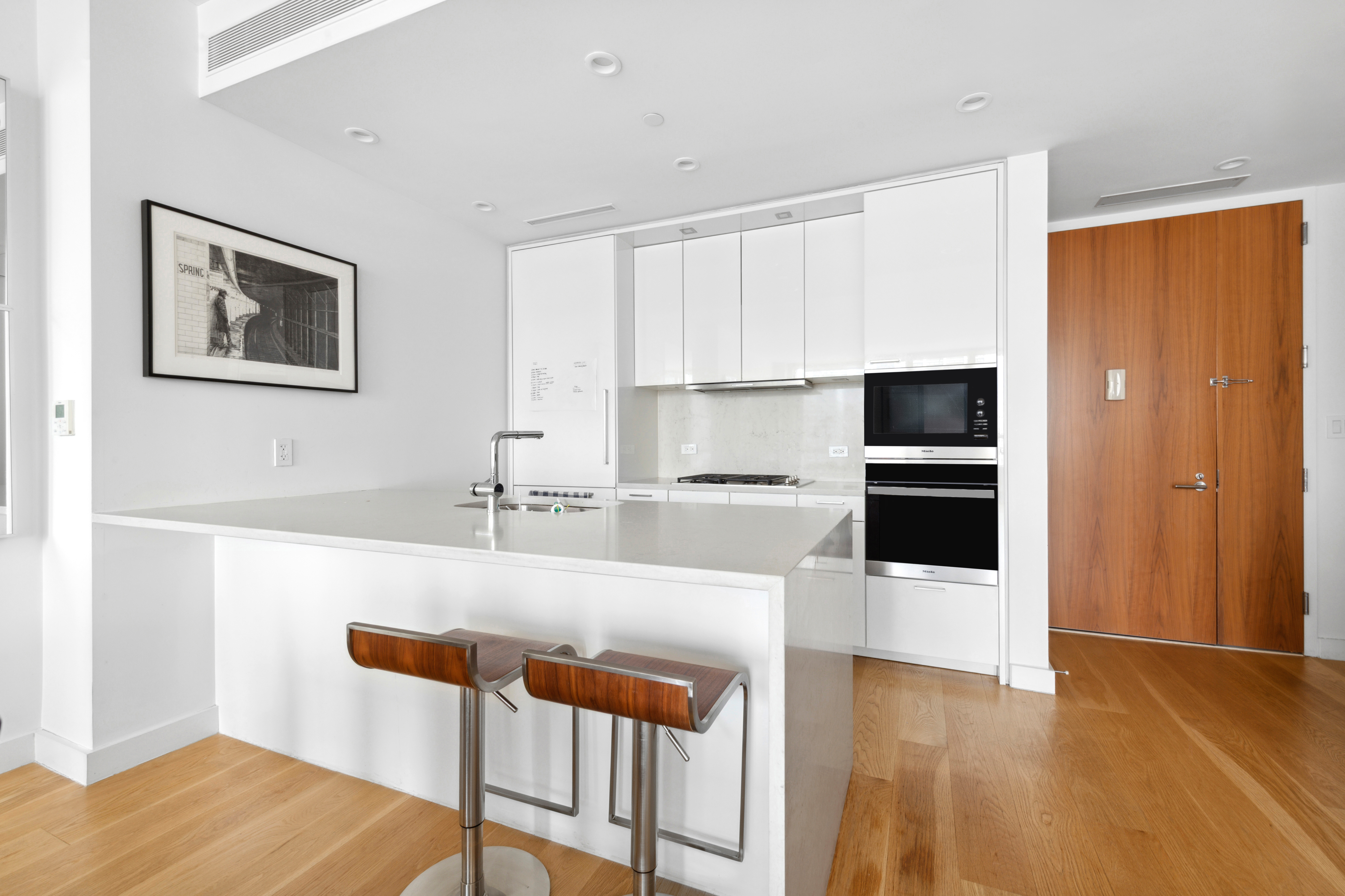 301 East 61st Street, Unit 12B Manhattan, NY 10065 - Photo 3 of 10 a kitchen with stainless steel appliances a refrigerator and a stove top oven