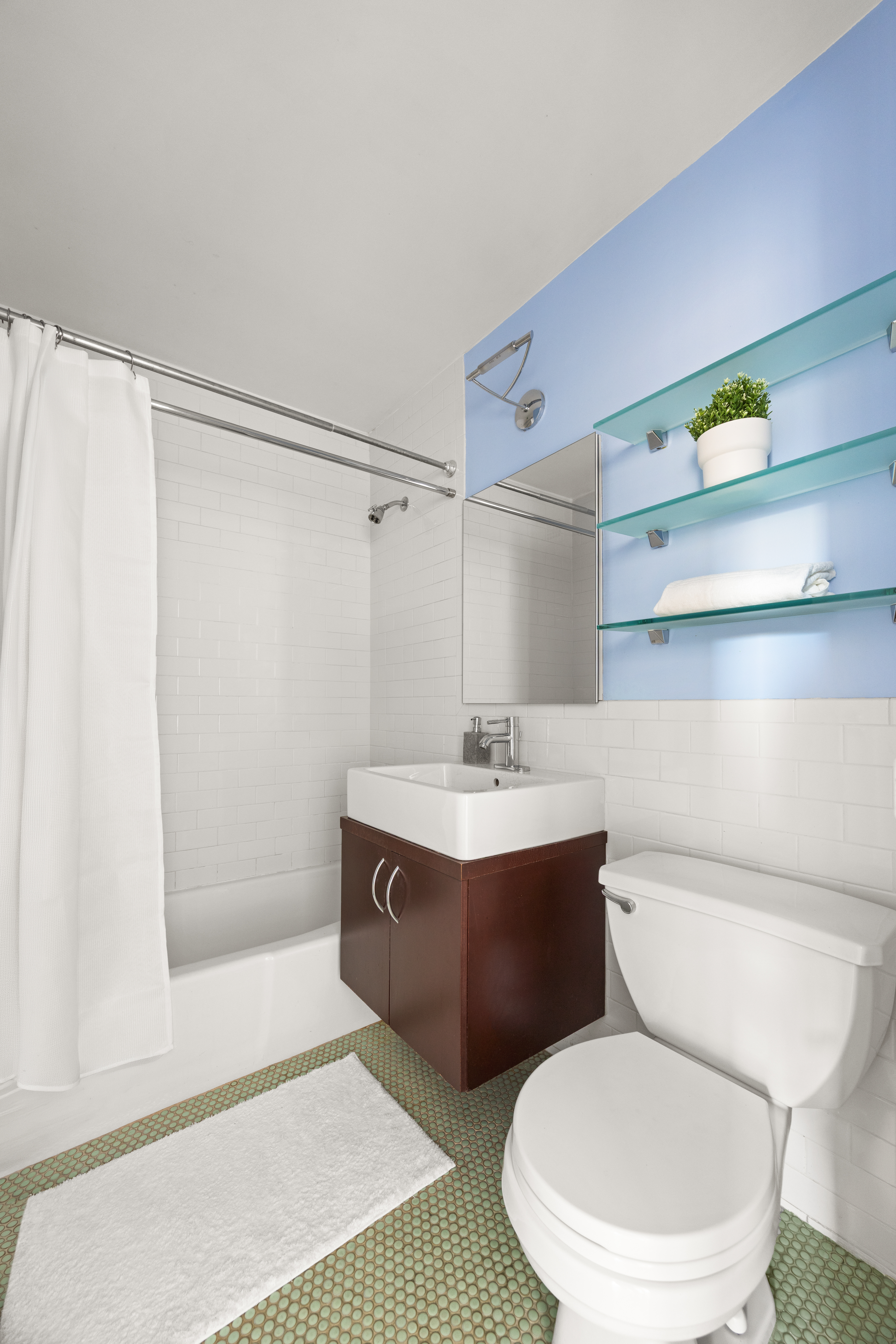 201 East 17th Street, Unit 14F Manhattan, NY 10003 - Photo 7 of 9 a bathroom with a sink a toilet a shower and a mirror