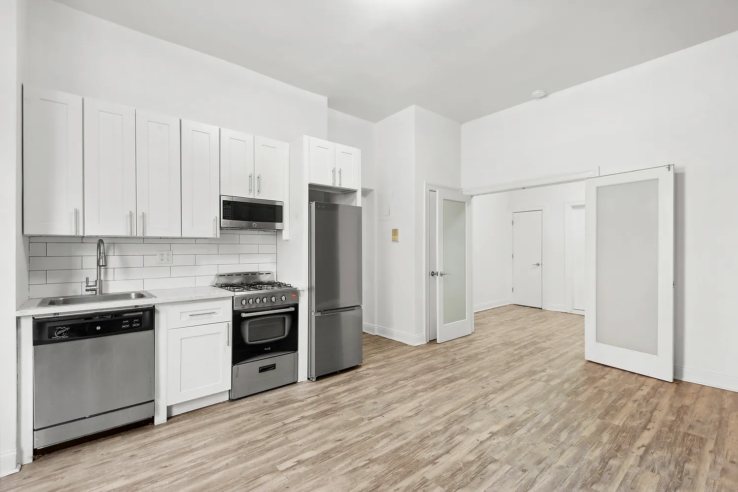 a kitchen with stainless steel appliances white cabinets and a refrigerator