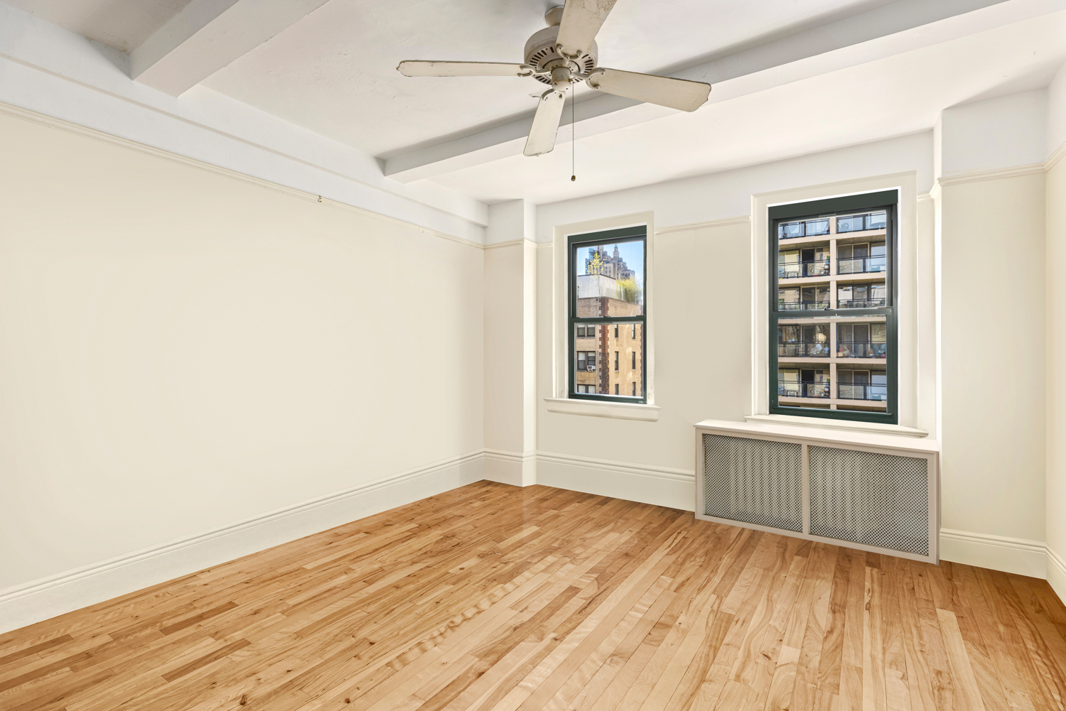 65 West 95th Street, Unit 8C Manhattan, NY 10025 - Photo 7 of 15 an empty room with wooden floor cabinet and windows