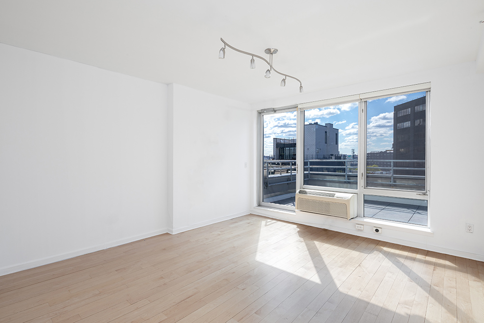 13-11 Jackson Avenue, Unit 9B Queens, NY 11101 - Photo 2 of 11 a view of empty room with wooden floor and windows