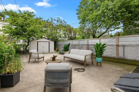 a backyard of a house with fountain table and chairs
