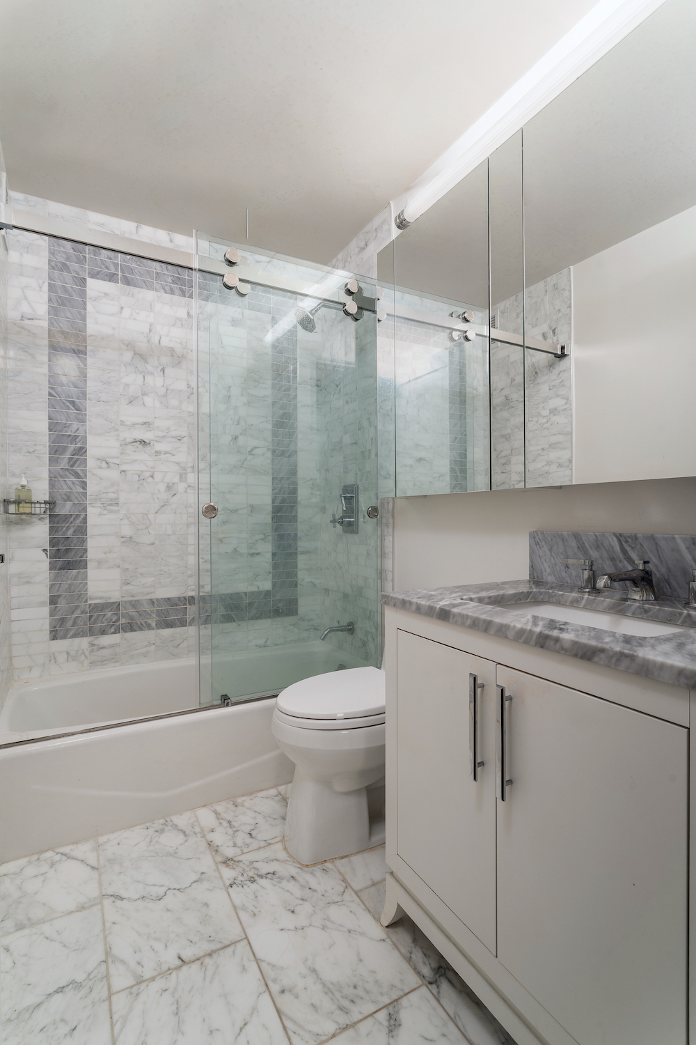 200 East 94th Street, Unit 2015 Manhattan, NY 10128 - Photo 8 of 16 a bathroom with a granite countertop sink a toilet and shower