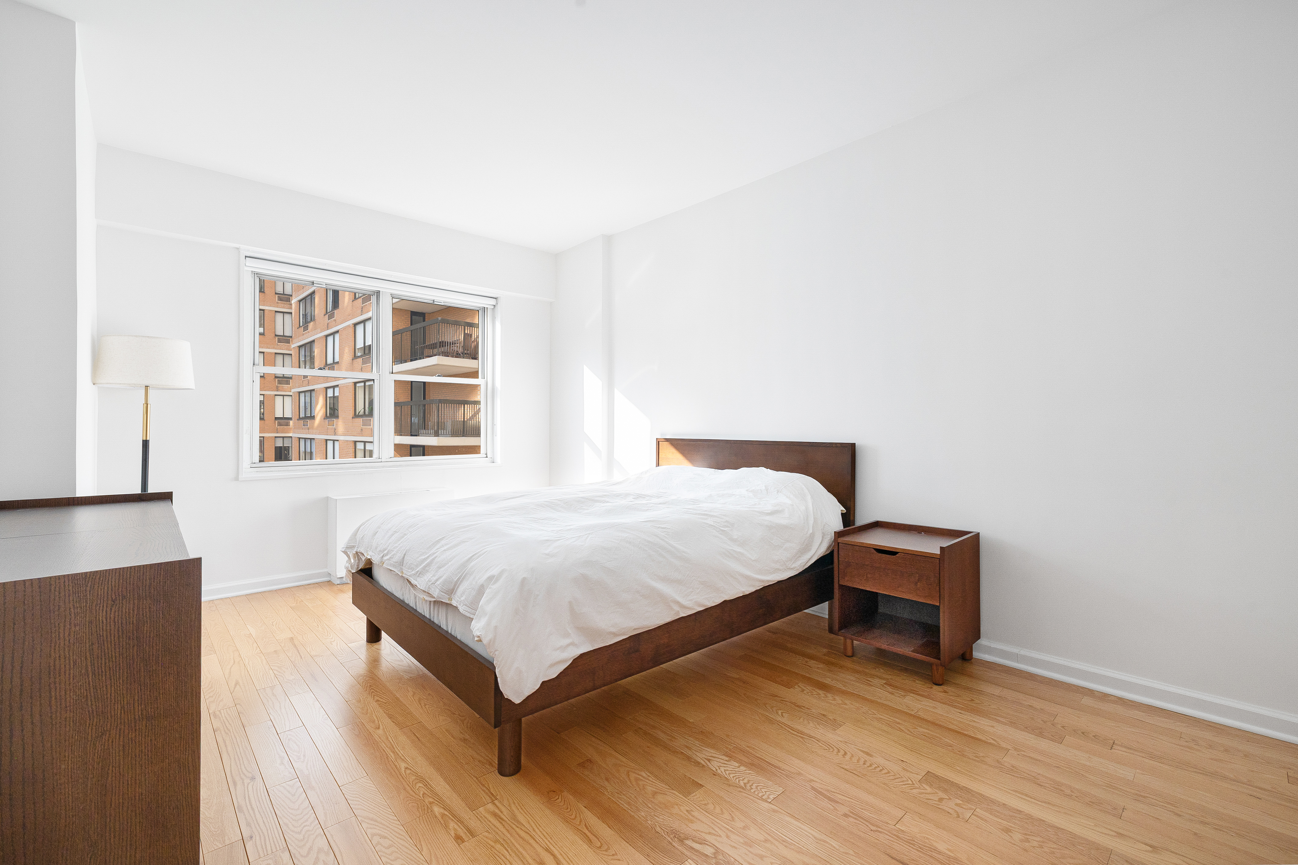 60 East 8th Street, Unit 15P Manhattan, NY 10003 - Photo 6 of 17 a bedroom with a bed and wooden floor