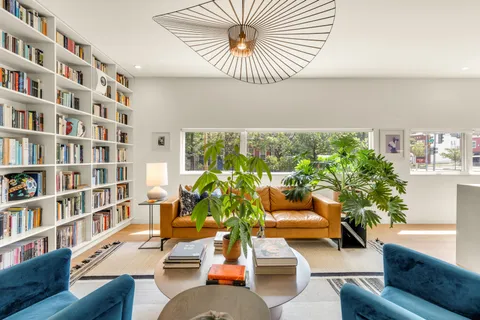 a living room with furniture and a book shelf