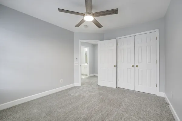 a view of an empty room and a ceiling fan