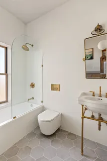 a bathroom with a sink mirror bathtub and toilet