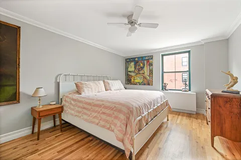 a bedroom with a bed and a dresser next to a window