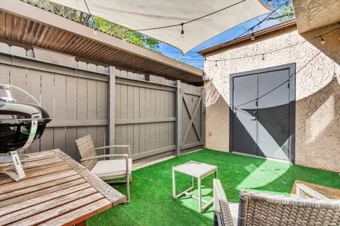 a view of a backyard with chairs potted plants and wooden fence