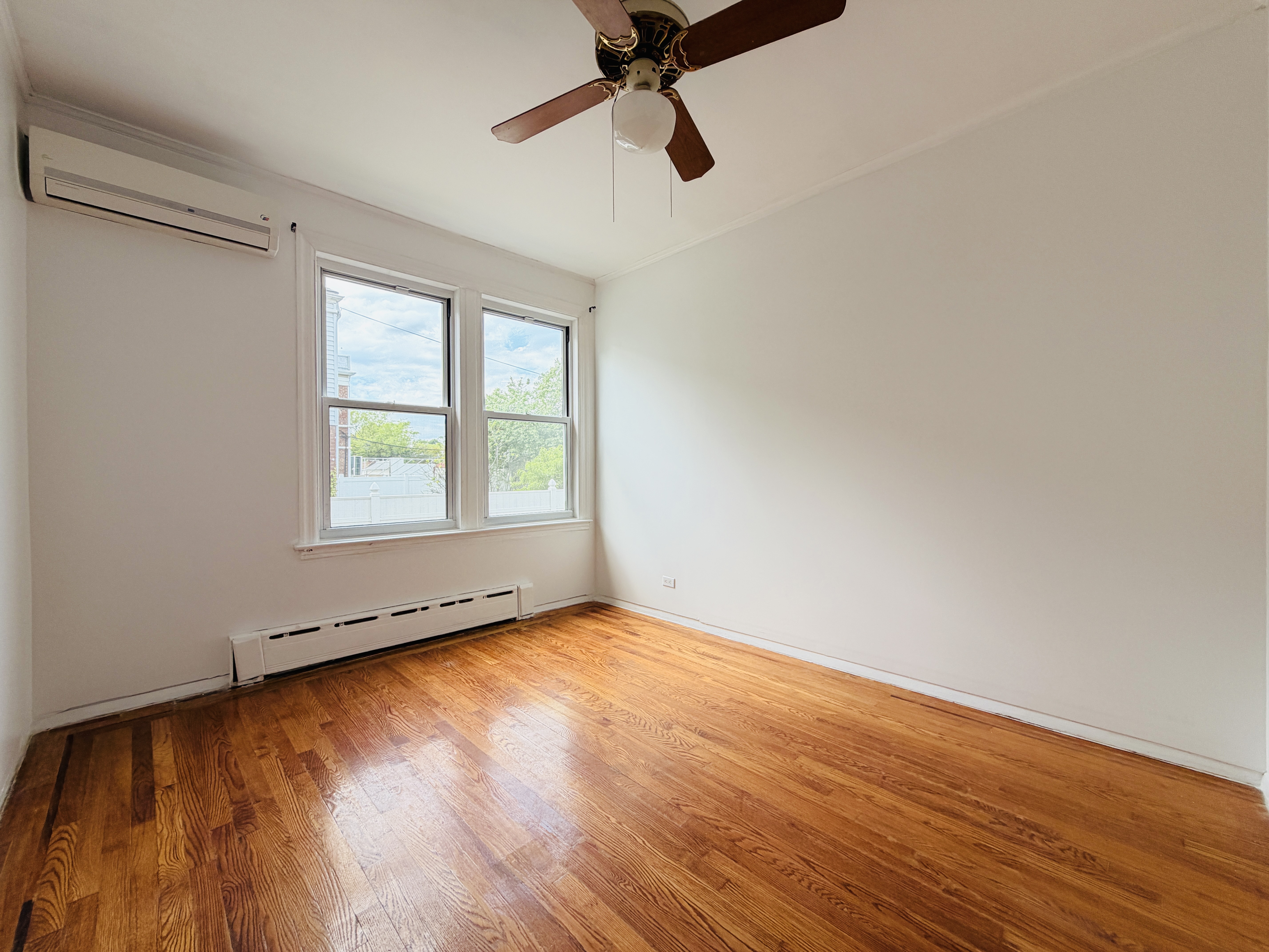 63-33 Haring Street, Unit 1F Queens, NY 11374 - Photo 10 of 13 a view of an empty room with wooden floor and a window