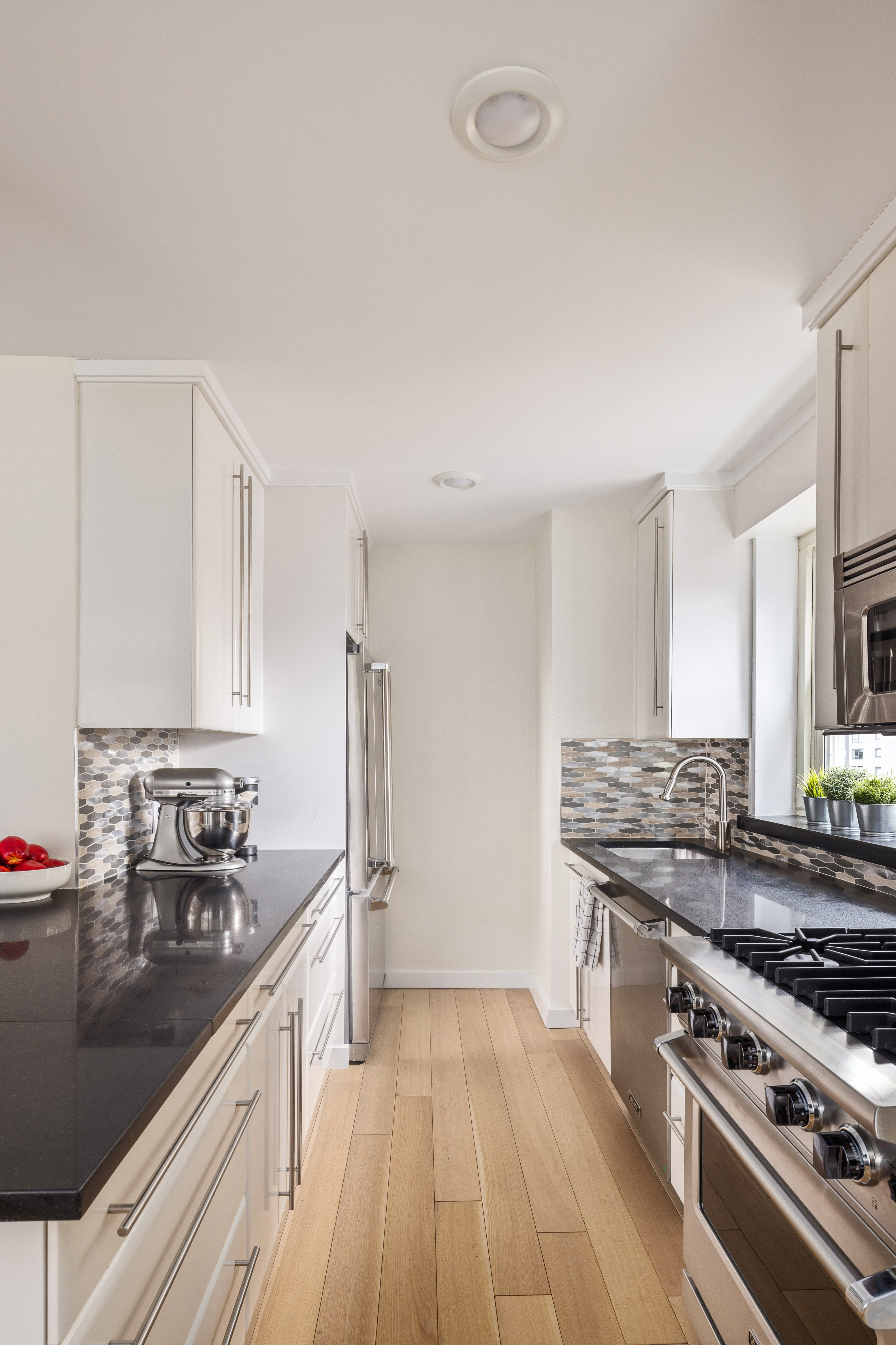 159 West 53rd Street, Unit 34E Manhattan, NY 10019 - Photo 7 of 15 a kitchen with stainless steel appliances a stove a sink and a refrigerator