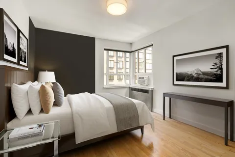 a bedroom with a bed and a large window