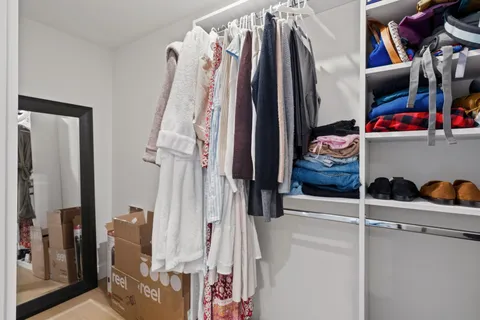 a bedroom with a bed and a flat tv screen on dresser