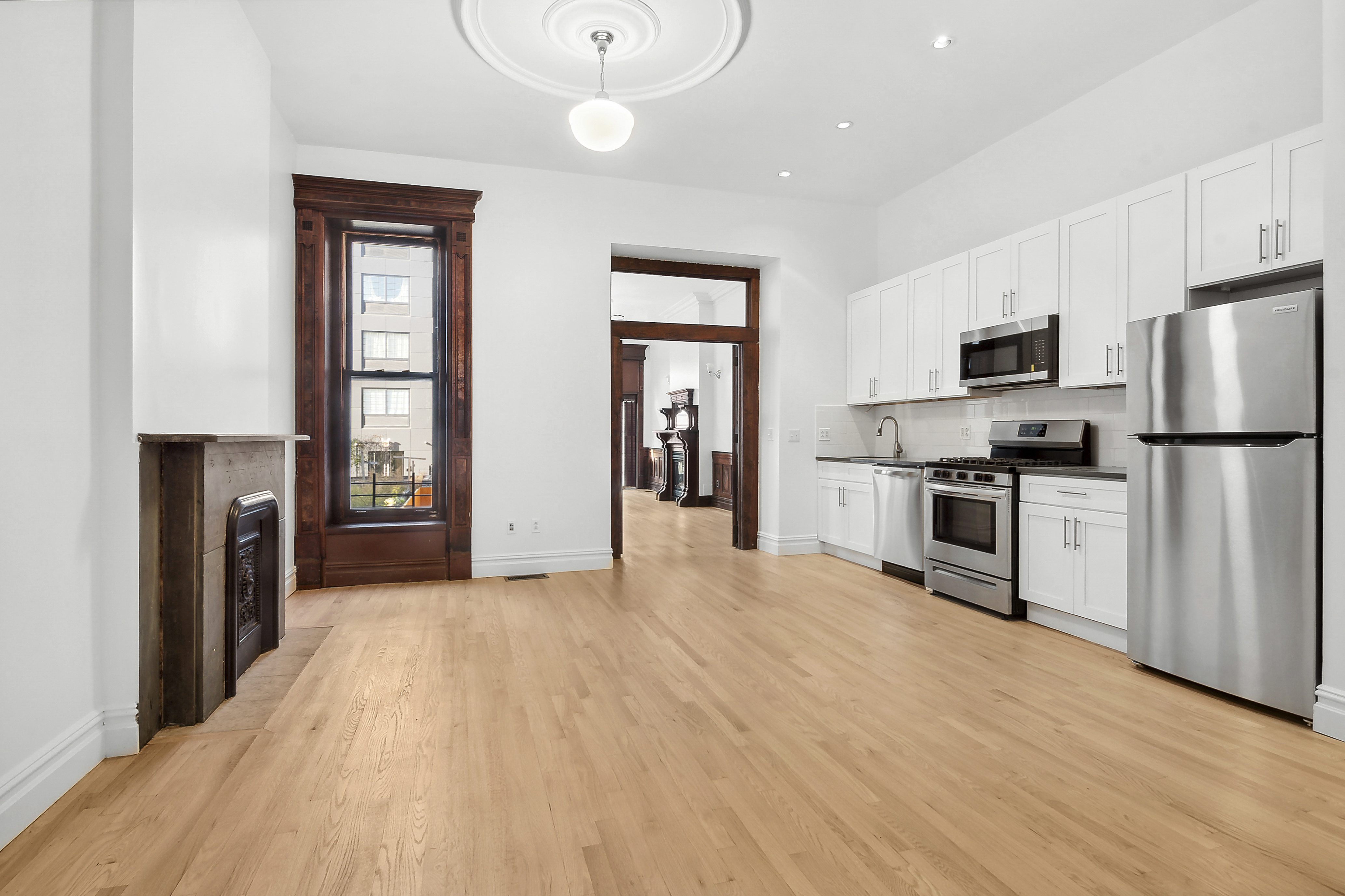 562 Washington Avenue, Unit 1 Brooklyn, NY 11238 - Photo 4 of 12 a kitchen with granite countertop a refrigerator and a stove top oven