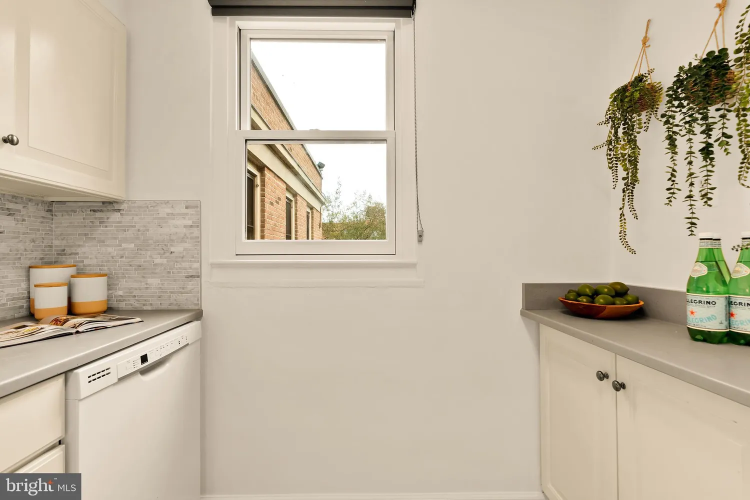 a kitchen with a sink and a stove with wooden floor