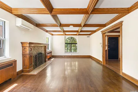 a view of empty room with a fireplace and wooden floor