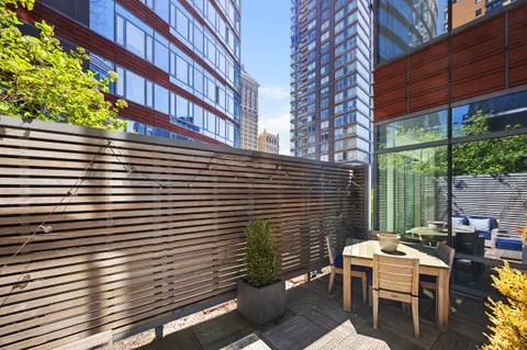 a view of a patio with a table and chairs next to a yard