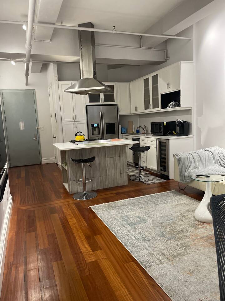 43-45 East 30th Street, Unit 8D Manhattan, NY 10016 - Photo 6 of 11 a living room with stainless steel appliances furniture a rug and a kitchen view