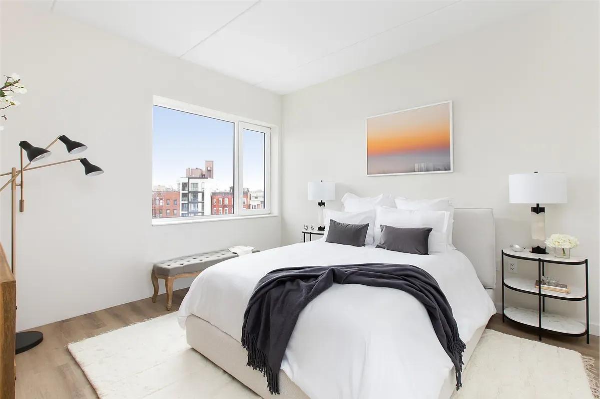 a bedroom with a bed and a lamp with the wooden floor