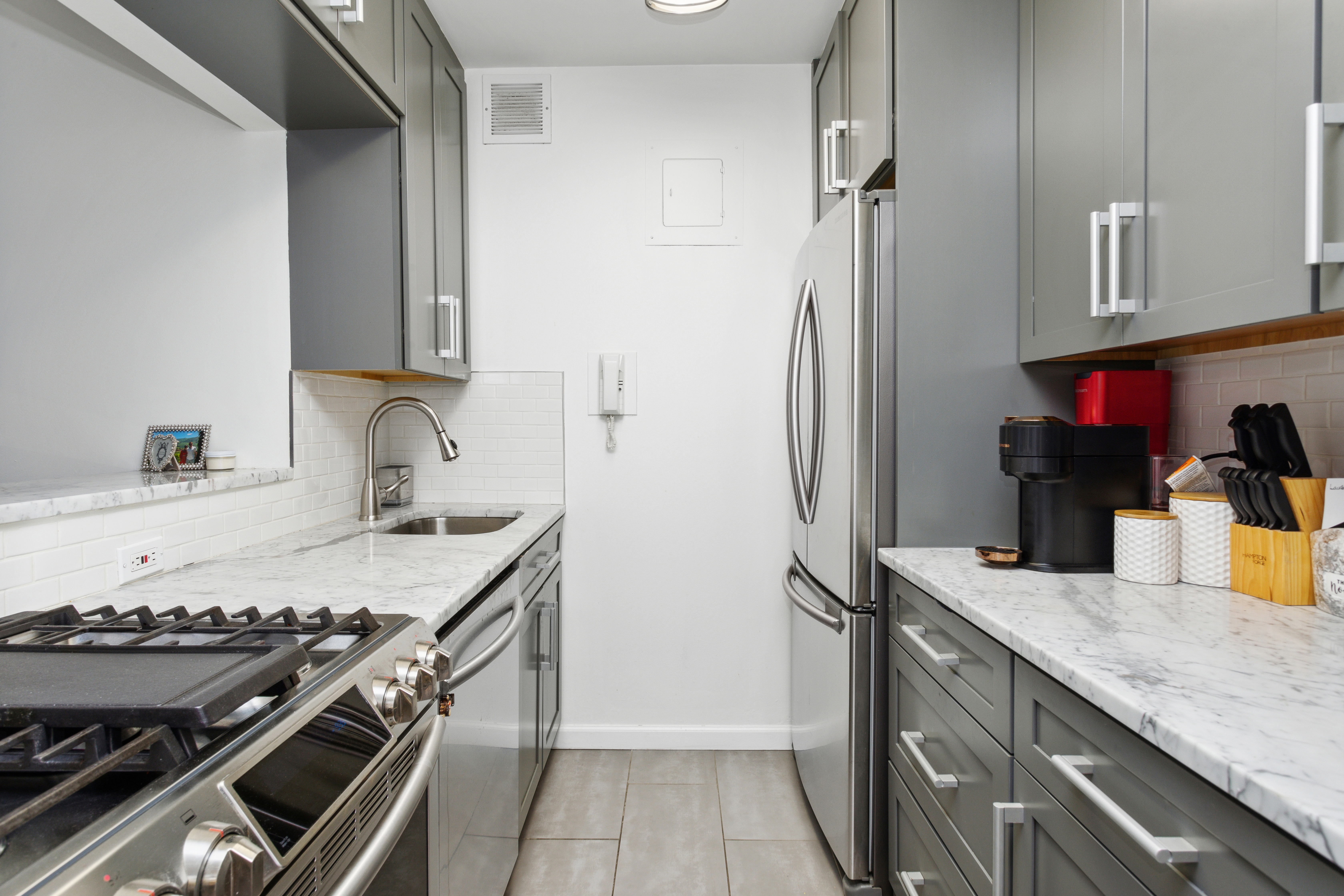 400 East 54th Street, Unit 7D Manhattan, NY 10022 - Photo 2 of 6 a kitchen with granite countertop a sink stove and refrigerator