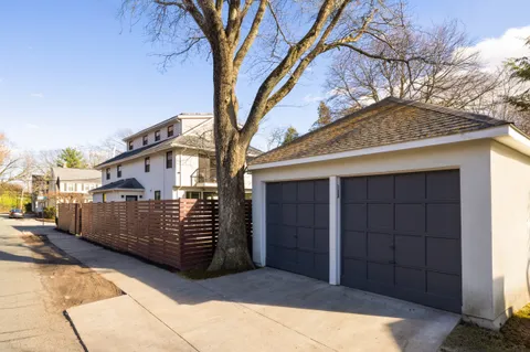 a view of a house with a wooden fence and a large tree