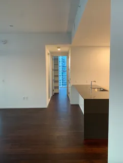 a view of a livingroom with wooden floor and a sink