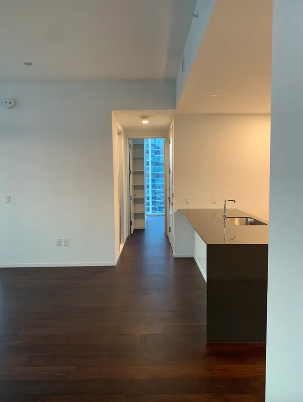 a view of a livingroom with wooden floor and a sink