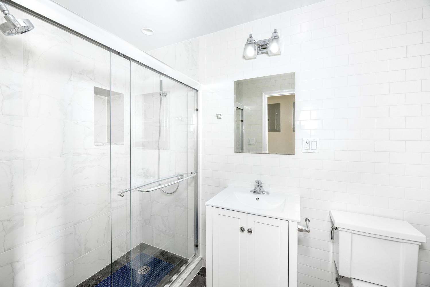 21 Downing Street, Unit 4 Manhattan, NY 10014 - Photo 4 of 6 a bathroom with a shower sink and mirror