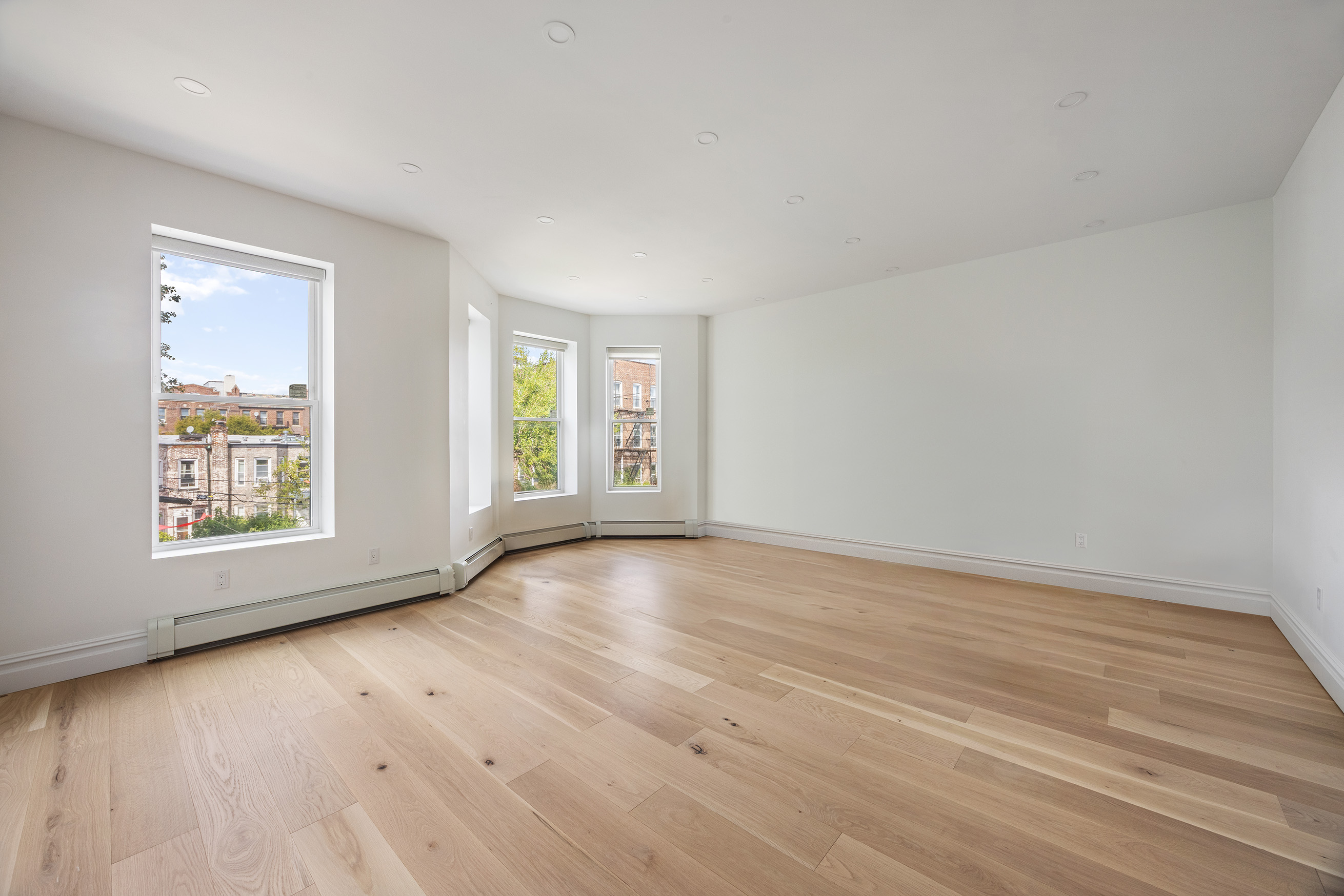 1423 Park Place Brooklyn, NY 11213 - Photo 11 of 17 an empty room with wooden floor and windows