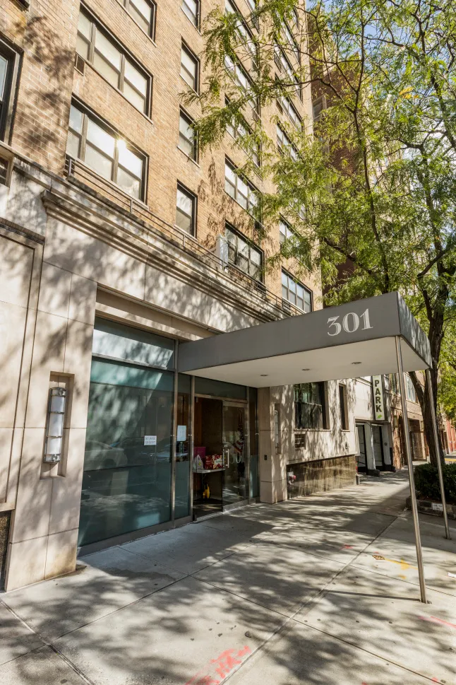 a view of a brick building with a large tree