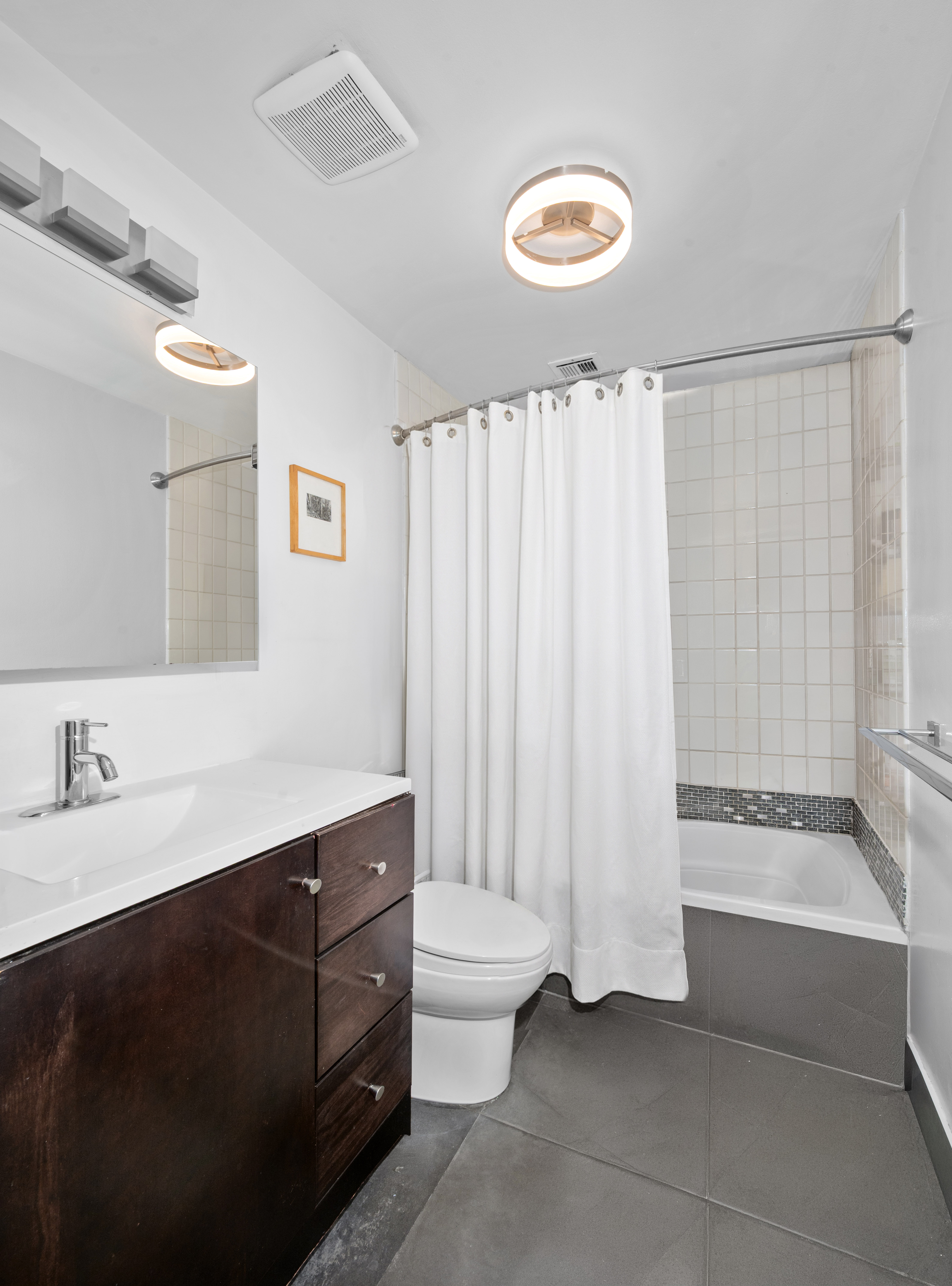 195 Spencer Street, Unit 9A Brooklyn, NY 11205 - Photo 6 of 8 a bathroom with a double vanity sink toilet and a tub