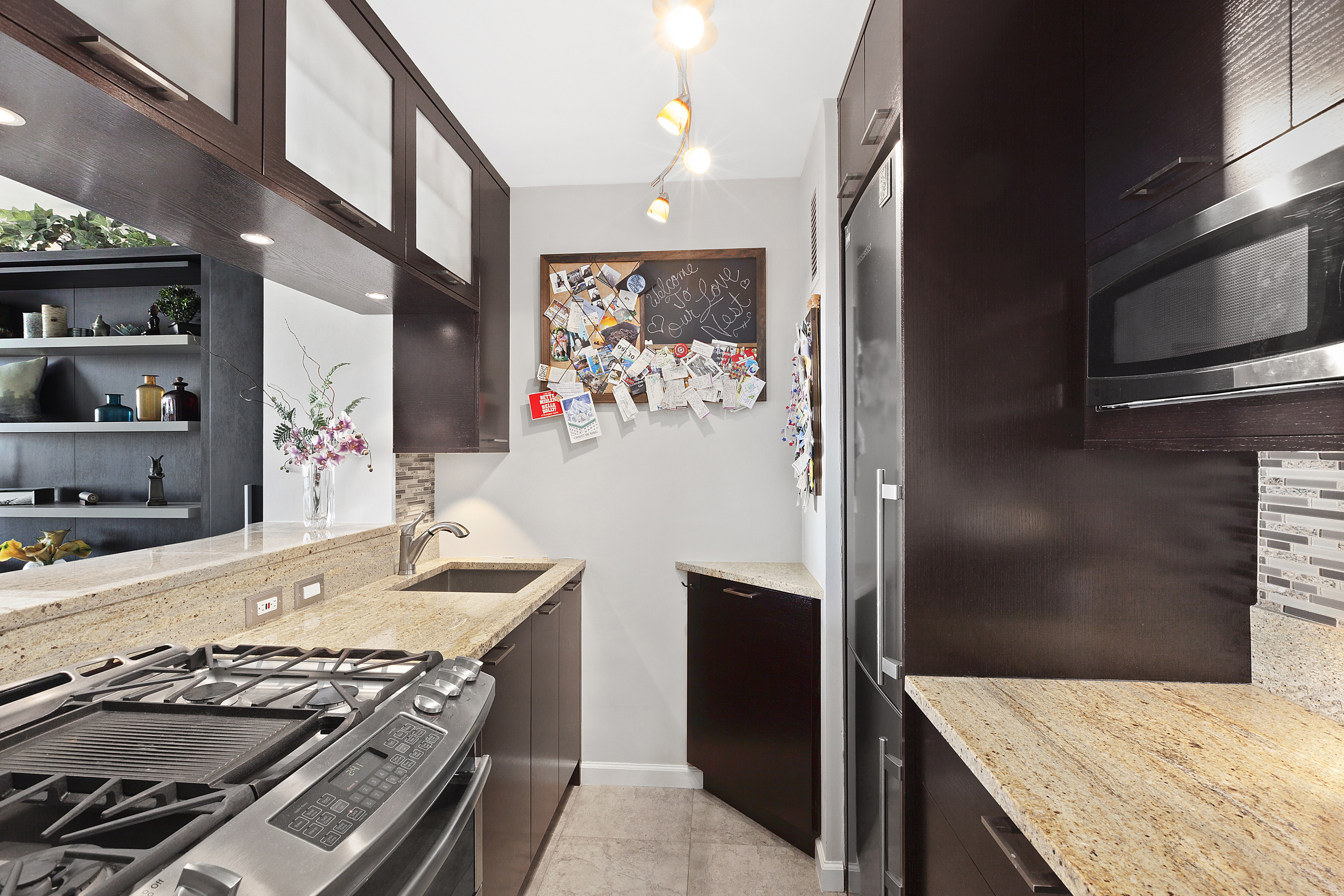 2025 Broadway, Unit 29G Manhattan, NY 10023 - Photo 3 of 10 a kitchen with stainless steel appliances granite countertop a stove and a refrigerator