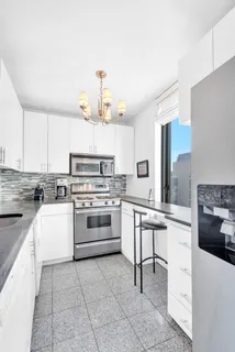 a kitchen with a stove white cabinets and white appliances
