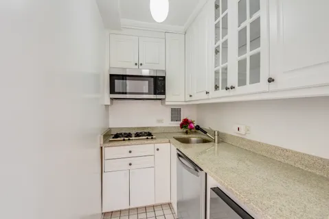 a kitchen with stainless steel appliances granite countertop a sink a stove and microwave