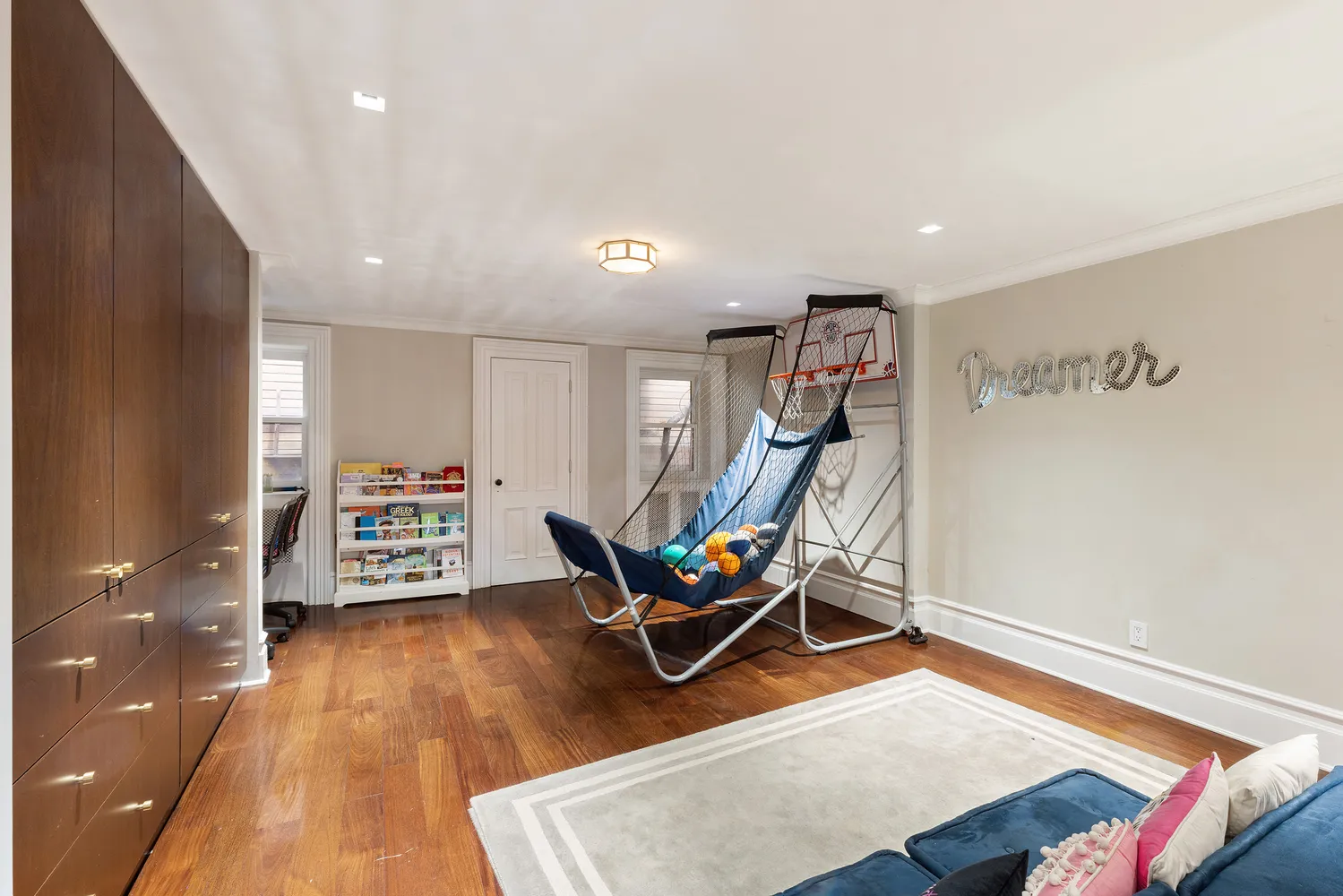 a bedroom with a bed a flat tv screen and next to a window