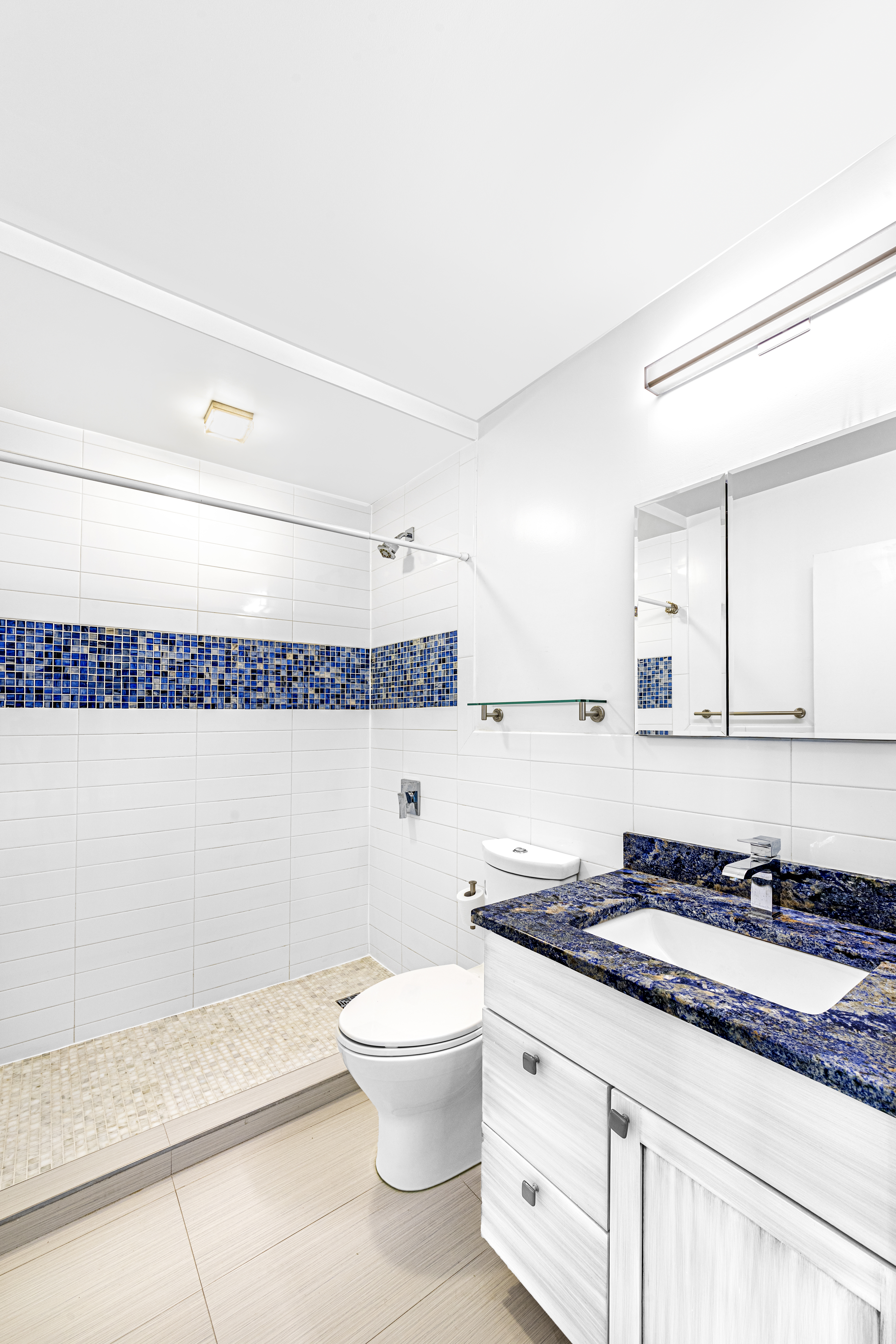 137 East 36th Street, Unit 8H Manhattan, NY 10016 - Photo 6 of 13 a bathroom with a granite countertop sink a toilet and a mirror