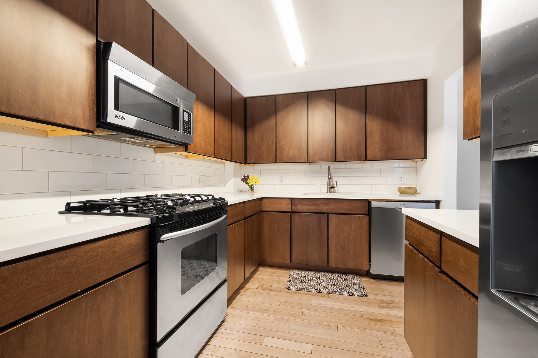 163 St Nicholas Avenue, Unit PH7A Manhattan, NY 10026 - Photo 3 of 11 a kitchen with stainless steel appliances a stove microwave and sink