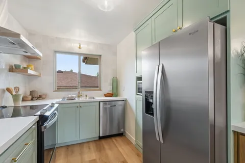 a kitchen with stainless steel appliances a sink stove and refrigerator
