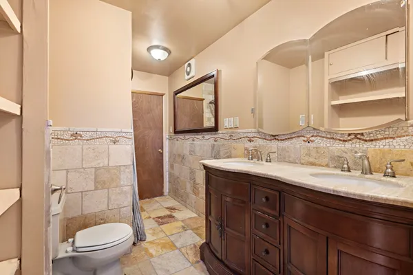 a bathroom with a granite countertop sink toilet and shower