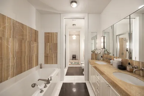 a bathroom with a tub sink and mirror