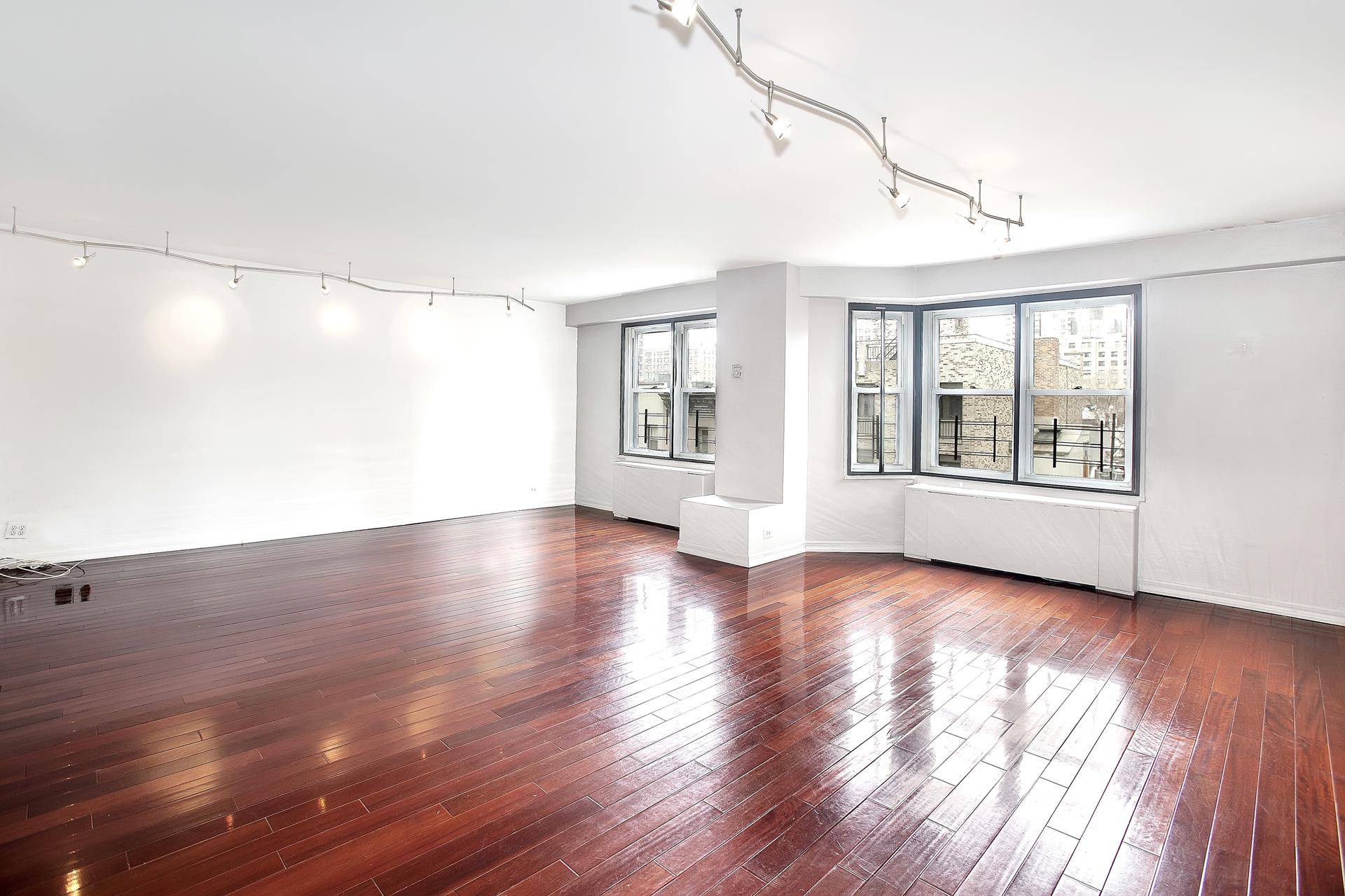 220 East 60th Street, Unit 7CD Manhattan, NY 10022 - Photo 3 of 11 a view of an empty room with wooden floor and a window