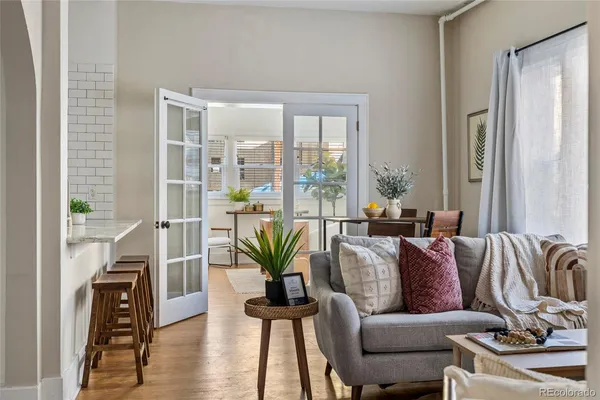 a living room with furniture floor to ceiling window and wooden floor