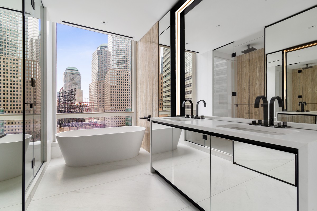 111 Murray Street, Unit 16B Manhattan, NY 10007 - Photo 10 of 22 a bathroom with a tub a sink and a large mirror