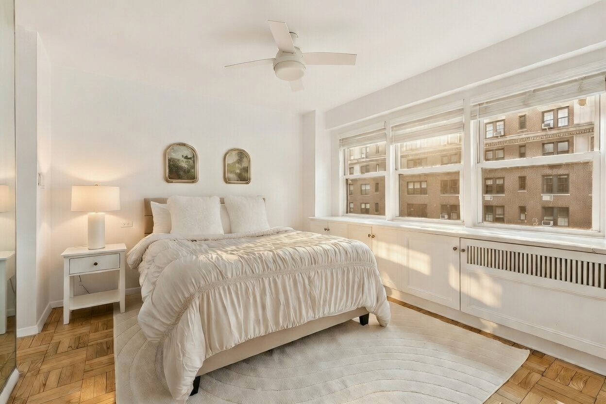 411 East 57th Street, Unit 14F Manhattan, NY 10022 - Photo 3 of 8 a bedroom with a bed and a large window