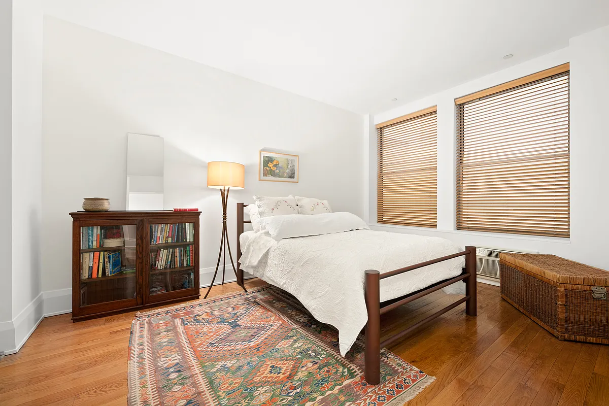 102 Fulton Street, Unit 2E Manhattan, NY 10038 - Photo 3 of 7 a spacious bedroom with a bed and a dresser next to a window