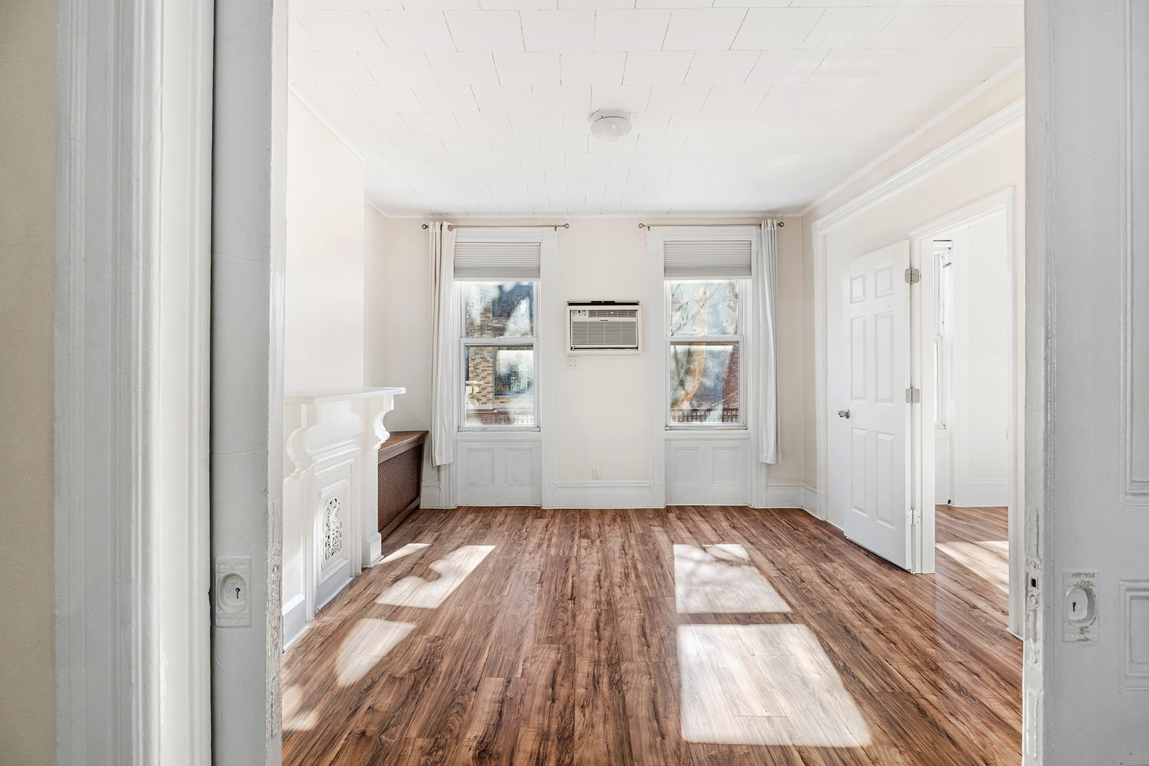239 Withers Street Brooklyn, NY 11211 - Photo 10 of 14 a view of a hallway with wooden floor and a living room